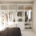 Camera da letto moderna con grande armadio guardaroba bianco a parete e finiture chiare